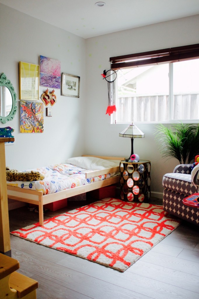 Bright little boy's bedroom with red and white rug and eclectic gallery wall